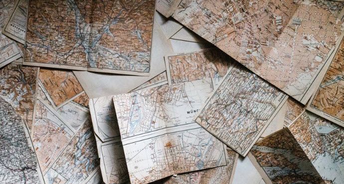 Image of maps scattered on a surface, no reference to anywhere certain and no links on this image